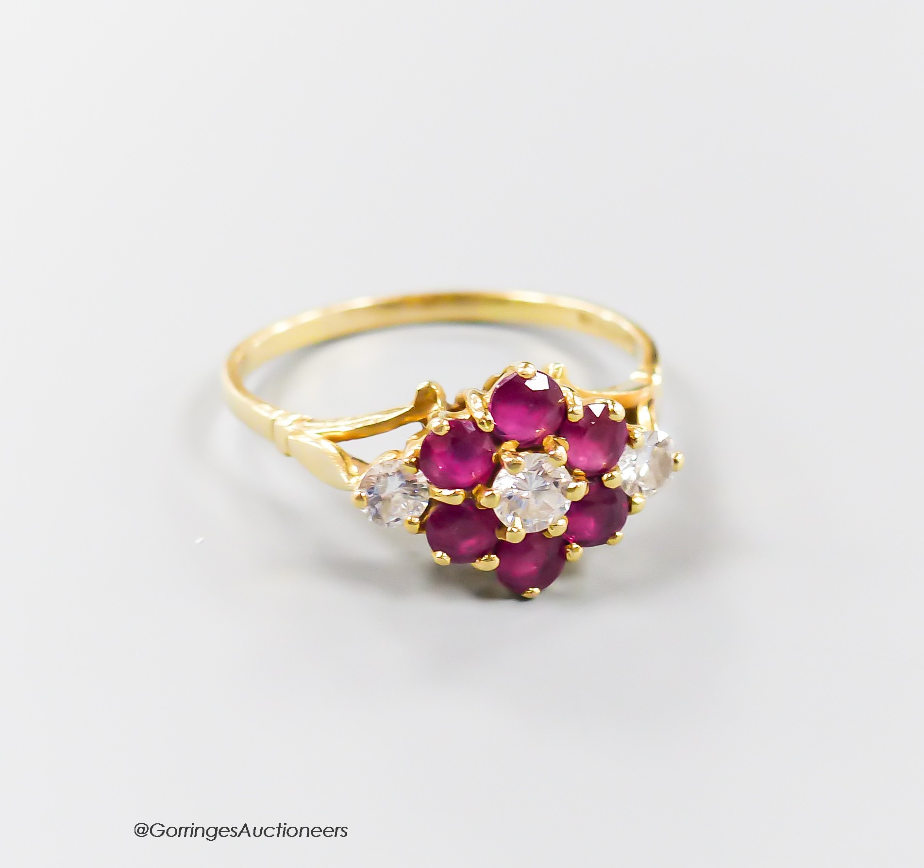 A modern 18ct gold, ruby and diamond set cluster ring, size T, gross 3.8 grams.